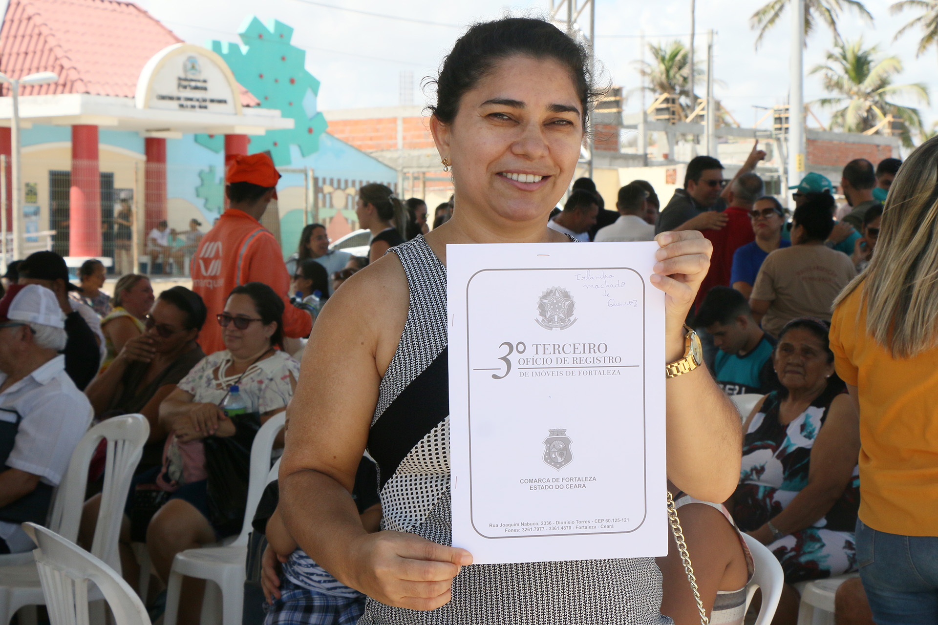 mulher posando para a foto segurando e mostrando documento